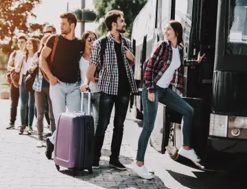 Group of Young People Boarding on Travel Bus. Happy Travelers Standing in Queue Holding Luggage Waiting their turn to Enter Bus. Traveling, Tourism and People Concept. Summer Vacation