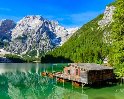 Lake Braies (also known as Pragser Wildsee or Lago di Braies) in Dolomites Mountains, Sudtirol, Italy. Romantic place with typical wooden boats on the alpine lake.  Hiking travel and adventure. Seekofel in background.