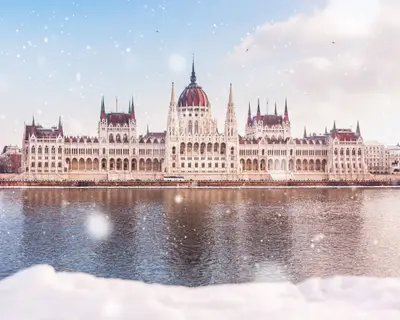 Hungarian parliament building at winter with snow. Snow lies on the river bank, Budapest, Hungary