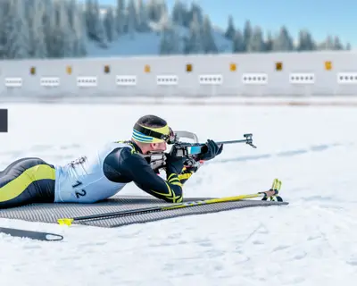 Biathlete lies and shoots a target at a 20 km race. Athlete with modern sports equipment for competition